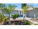Home entrance showcasing decorative plants, a walkway, and a charming blue front door at 9917 San Sierra Way, Port Richey, FL 34668