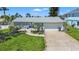 Well-maintained single-story home with a lush front yard and inviting curb appeal at 9917 San Sierra Way, Port Richey, FL 34668