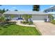 Charming single-story home featuring a well-manicured lawn and beautiful landscaping at 9917 San Sierra Way, Port Richey, FL 34668