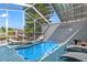 Relaxing screened-in pool area with lounge chairs, perfect for enjoying the outdoors in comfort at 9917 San Sierra Way, Port Richey, FL 34668