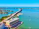 Aerial view of a waterfront building with access to a bridge, featuring beautiful turquoise waters at 100 Bluff View Dr # 114C, Belleair Bluffs, FL 33770