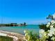 Serene beach view with lush vegetation and pristine turquoise waters under a clear blue sky near a quaint bridge at 100 Bluff View Dr # 114C, Belleair Bluffs, FL 33770