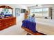 Bright bedroom with ample natural light, a comfortable bed, and a dresser with a mirror at 100 Bluff View Dr # 114C, Belleair Bluffs, FL 33770