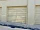 Single car garage features a sturdy door and a minimalist exterior at 100 Bluff View Dr # 114C, Belleair Bluffs, FL 33770