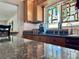 Cozy kitchen showcasing granite countertops, tile backsplash, and a unique window feature at 100 Bluff View Dr # 114C, Belleair Bluffs, FL 33770