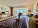 Bright living room featuring a patterned rug, comfortable seating, and an open view to an outdoor balcony dining area at 100 Bluff View Dr # 114C, Belleair Bluffs, FL 33770