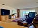 Comfortable living room with a large TV, stylish furniture, and access to a balcony at 100 Bluff View Dr # 114C, Belleair Bluffs, FL 33770