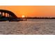 Captivating waterfront at sunset showcasing a nearby bridge and glistening water reflecting the sun's golden glow at 100 Bluff View Dr # 114C, Belleair Bluffs, FL 33770