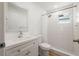 Modern bathroom with a tiled shower, vanity, and well-lit mirror for a fresh and clean space at 10219 Huntley St, New Port Richey, FL 34654