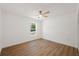 Bright bedroom features wood-look floors, a ceiling fan, and a window providing natural light at 10219 Huntley St, New Port Richey, FL 34654