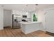 Modern kitchen with stainless steel appliances, white cabinets, and a breakfast bar for casual dining at 10219 Huntley St, New Port Richey, FL 34654