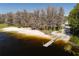 A beautiful lake view with a sandy beach, a pier, and lush greenery, creating a serene outdoor experience at 10219 Huntley St, New Port Richey, FL 34654
