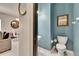 Clean bathroom with blue walls featuring a modern sink and toilet at 10606 Shady Falls Ct, Riverview, FL 33578