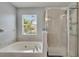 Bright bathroom with a soaking tub and glass shower enclosure with tiled walls at 10606 Shady Falls Ct, Riverview, FL 33578