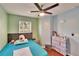 Comfortable bedroom with pastel-colored walls, dark wood floor, ceiling fan and a plush bed at 10606 Shady Falls Ct, Riverview, FL 33578