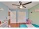 Bright bedroom with a ceiling fan, wood floors, and a double door closet at 10606 Shady Falls Ct, Riverview, FL 33578