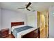 Cozy bedroom featuring a ceiling fan, wood floors, and closet space, illuminated by natural light at 10606 Shady Falls Ct, Riverview, FL 33578