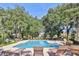 Relaxing community pool and lounge area surrounded by mature trees and landscaping at 10606 Shady Falls Ct, Riverview, FL 33578