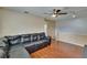 Spacious living room featuring hardwood floors, ceiling fan, and a comfortable black leather couch at 10606 Shady Falls Ct, Riverview, FL 33578