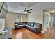 Comfortable living room features dark wood floors, ceiling fan, modern furnishings, and a large sectional couch at 10606 Shady Falls Ct, Riverview, FL 33578
