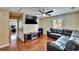Inviting living room with dark wood floors, modern ceiling fan, and comfortable leather sectional sofa at 10606 Shady Falls Ct, Riverview, FL 33578