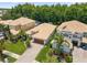 An aerial view of the home features a well-manicured lawn, landscaping, and brown tile roof at 10880 Cory Lake Dr, Tampa, FL 33647