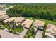 Aerial view showcases the community with lush landscaping, multiple residences, pool and beautiful wooded backdrop at 10880 Cory Lake Dr, Tampa, FL 33647
