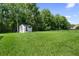Expansive backyard featuring green lawn, mature trees, and a storage shed at 10880 Cory Lake Dr, Tampa, FL 33647