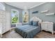 Bright bedroom featuring two large windows, white furniture, and a bed with blue pillows at 10880 Cory Lake Dr, Tampa, FL 33647