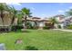Charming single-story home featuring a well-manicured lawn and mature palm tree landscaping at 10880 Cory Lake Dr, Tampa, FL 33647
