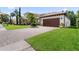A home with a dark-stained, two car garage and a brick-paved driveway at 10880 Cory Lake Dr, Tampa, FL 33647