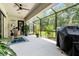 Screened in patio with an outdoor kitchen, barbecue, and seating areas for dining or relaxing at 10880 Cory Lake Dr, Tampa, FL 33647