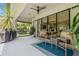 Relaxing screened patio with comfortable seating and ceiling fan, perfect for outdoor enjoyment at 10880 Cory Lake Dr, Tampa, FL 33647
