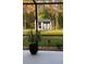 View from screened in porch to Backyard shed providing extra storage with green grass and trees at 10880 Cory Lake Dr, Tampa, FL 33647