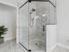 Close up of the marble shower featuring patterned accent tile, black hardware, and a glass enclosure at 10880 Cory Lake Dr, Tampa, FL 33647