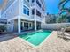 Exterior rear view of the home showing a private pool area with a dining table and outdoor kitchen at 1204 Derby Ln, Sarasota, FL 34242