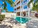 A multi-story home with balconies overlooks a sparkling pool, an outdoor kitchen, and a covered dining area at 1204 Derby Ln, Sarasota, FL 34242