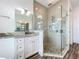 Modern bathroom showcasing a glass shower, neutral tile, and a vanity with a stone countertop at 1204 Derby Ln, Sarasota, FL 34242