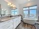 Bright bathroom featuring a soaking tub, a granite topped vanity, and a large mirror at 1204 Derby Ln, Sarasota, FL 34242
