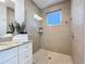 An elegant bathroom features a glass shower with tiled walls, granite countertops, and ample lighting at 1204 Derby Ln, Sarasota, FL 34242