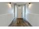 Inviting entryway with wood-look flooring and wainscoting, leading to the front door at 1204 Derby Ln, Sarasota, FL 34242