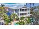 Beautiful three-story home featuring balconies, a pool, and lush palm trees surrounding the property at 1204 Derby Ln, Sarasota, FL 34242