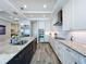 Bright kitchen with stainless steel appliances, marble countertops, and an island with bar seating and shelving at 1204 Derby Ln, Sarasota, FL 34242