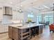 Bright kitchen with a large center island, modern pendant lighting, and views of the dining area and living space at 1204 Derby Ln, Sarasota, FL 34242