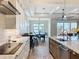 Modern kitchen featuring white cabinetry, stainless steel appliances, and a spacious island overlooking the dining area at 1204 Derby Ln, Sarasota, FL 34242