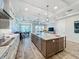 Open-concept kitchen with a large center island, stainless steel appliances, and views to the dining and living area at 1204 Derby Ln, Sarasota, FL 34242