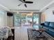 Bright living room with a ceiling fan and glass doors opening to a patio with a view of the pool area at 1204 Derby Ln, Sarasota, FL 34242