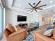 Spacious living room featuring comfortable seating, ceiling fan, and a media center with a large screen television at 1204 Derby Ln, Sarasota, FL 34242