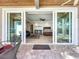 An open concept bedroom with hardwood floors, a ceiling fan, and sliding glass doors to the outdoor patio at 1204 Derby Ln, Sarasota, FL 34242