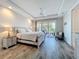 A bedroom with a sliding glass door leading to an outdoor balcony and a beautifully decorated bed at 1204 Derby Ln, Sarasota, FL 34242